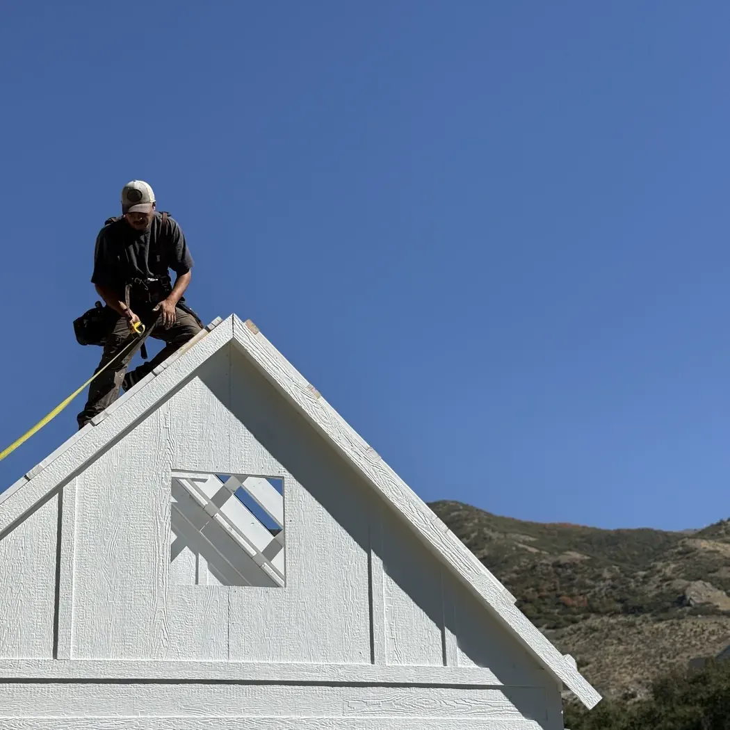 ShedPro LLC crew framing a gable roof above a wall of windows