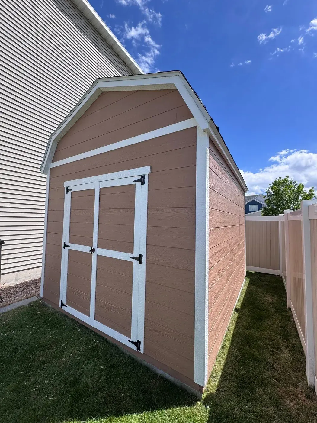 Mauve barn style shed with a gambrel roof, white trim and double doors, built on-site by ShedPro LLC