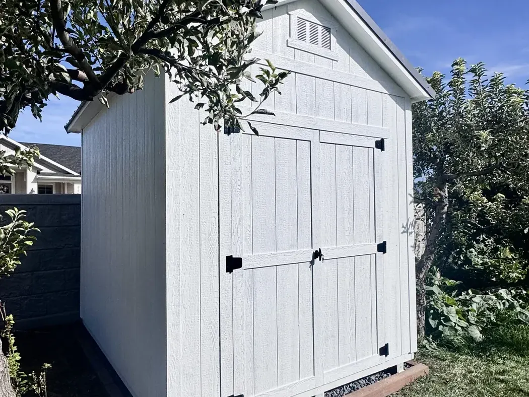 White A-frame gable shed with double doors and a gable vent on a gravel pad, built by ShedPro LLC