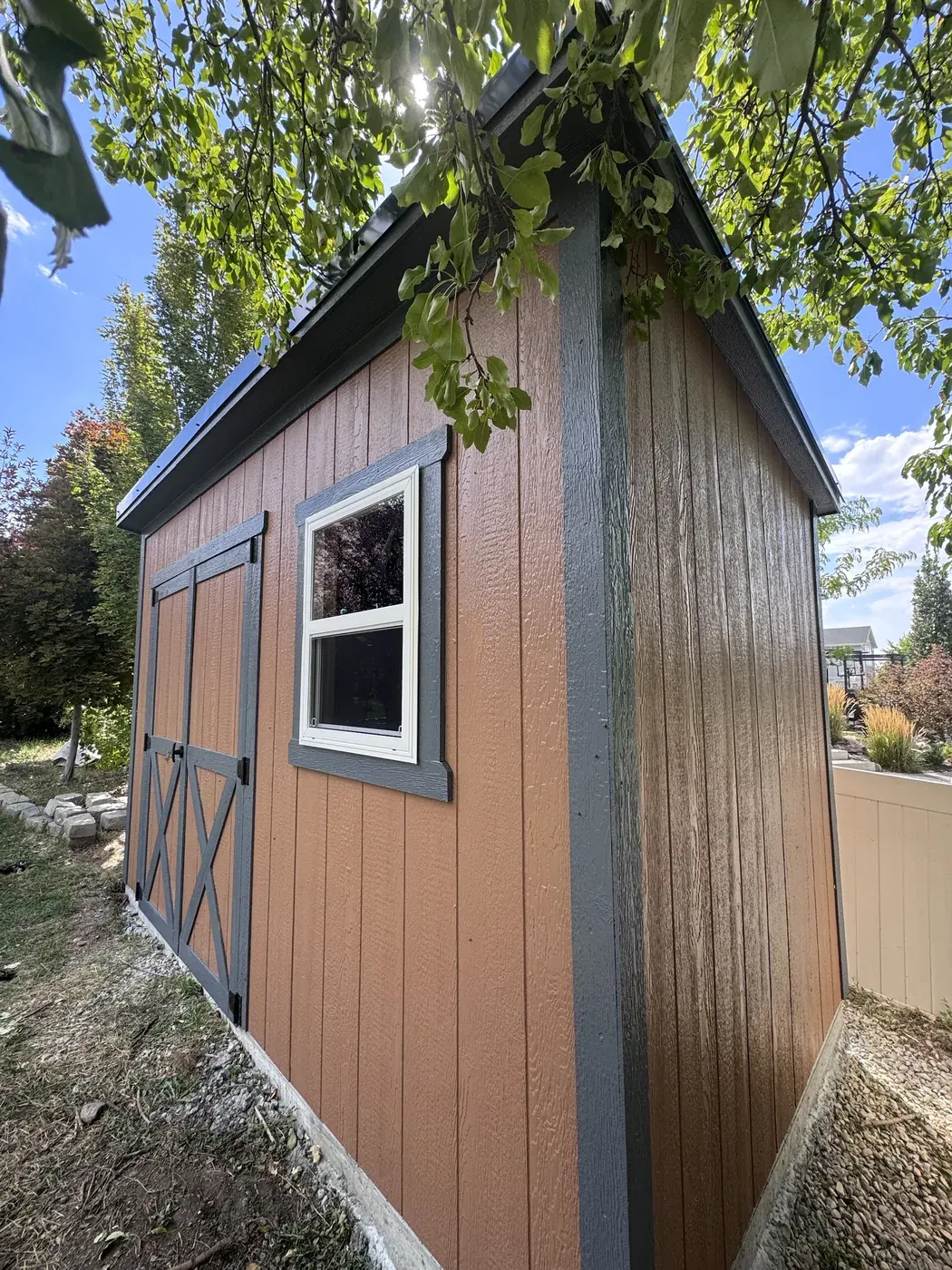 Terracotta lean-to shed with charcoal trim, X-brace doors and a single-hung window, built on-site by ShedPro LLC